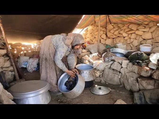 Nomadic life in Iran: Washing milk containers after milking goat