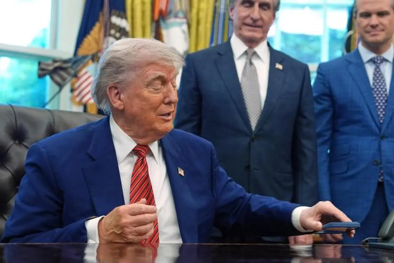 President Donald Trump silences his mobile phone which rang two...