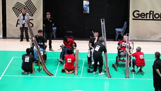 A group of people in wheelchairs on a green floor

AI-generated content may be incorrect.