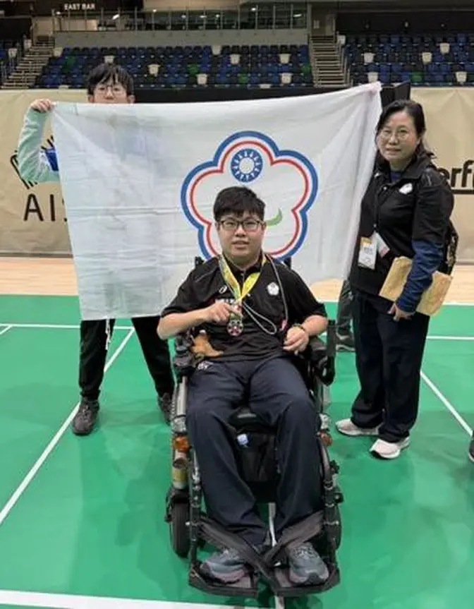 A person in a wheelchair holding a flag

AI-generated content may be incorrect.